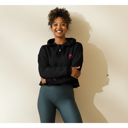 Woman wearing a black hoodie and teal shorts against a beige background