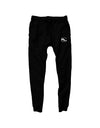 pair of black streetwear joggers by Something Light Clothing. The design features an elastic drawstring waistband and tapered legs with ribbed ankle cuffs. A white circular "SLC" monogram logo is prominently printed on the upper left thigh.