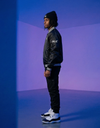 Apliiq SLC™ Varsity Bomber Jacket with striped collar and cuffs, navy body, and white sleeves, displayed on a hanger.